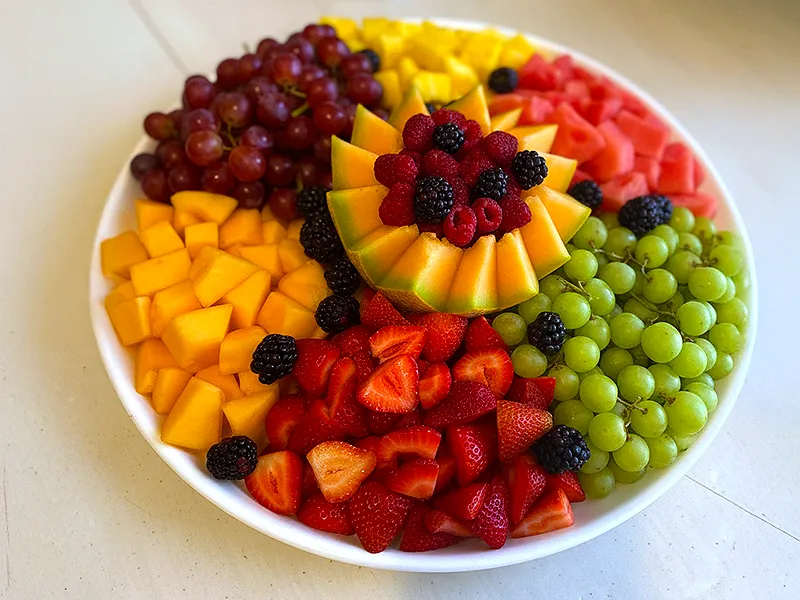 Colorful fresh fruit tray with melon, berries, grapes, pineapple